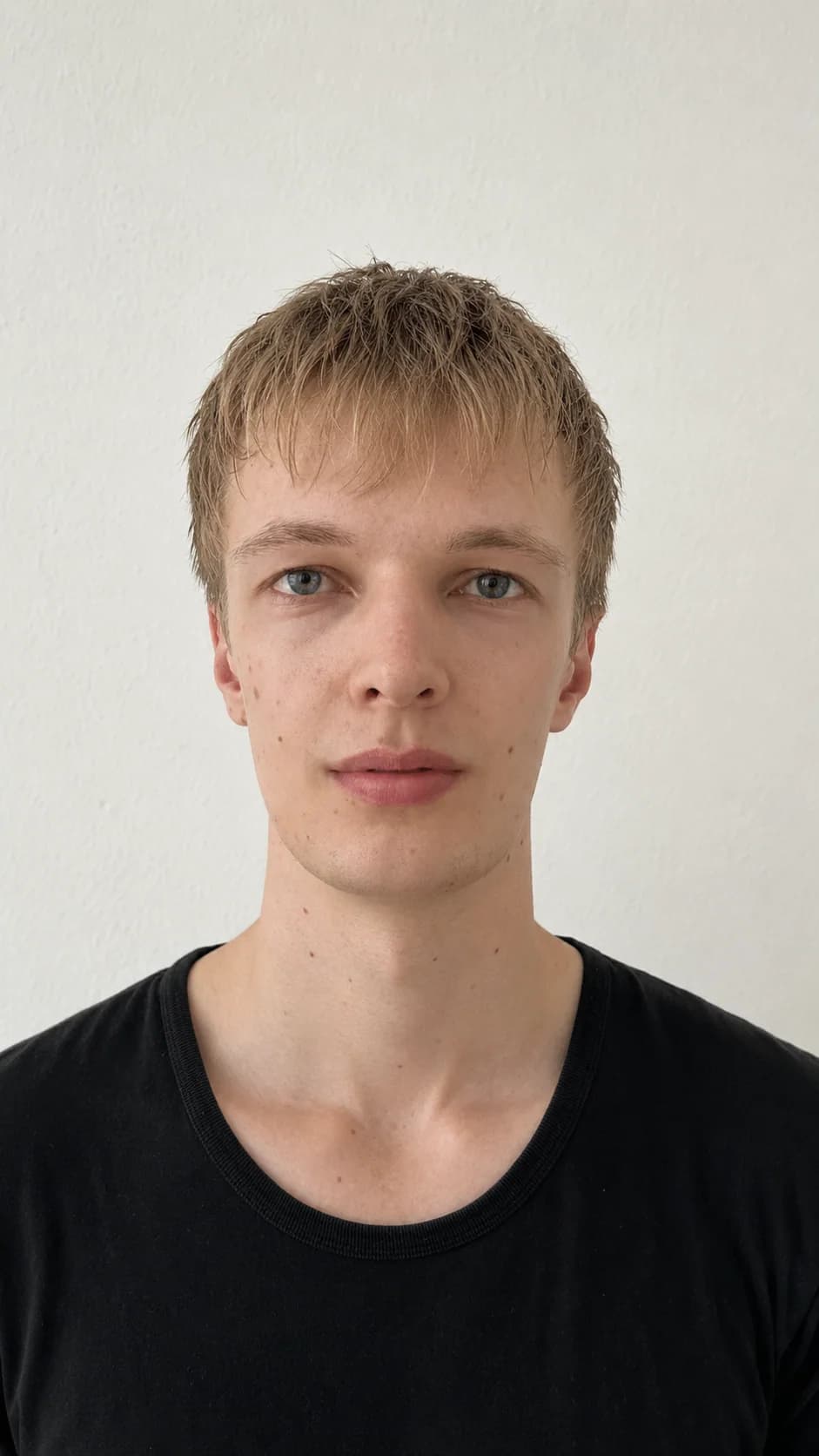 Ruhiges frontales Portrait von Lars Möllering vor heller Wand, schwarzes Shirt, neutraler Blick.
