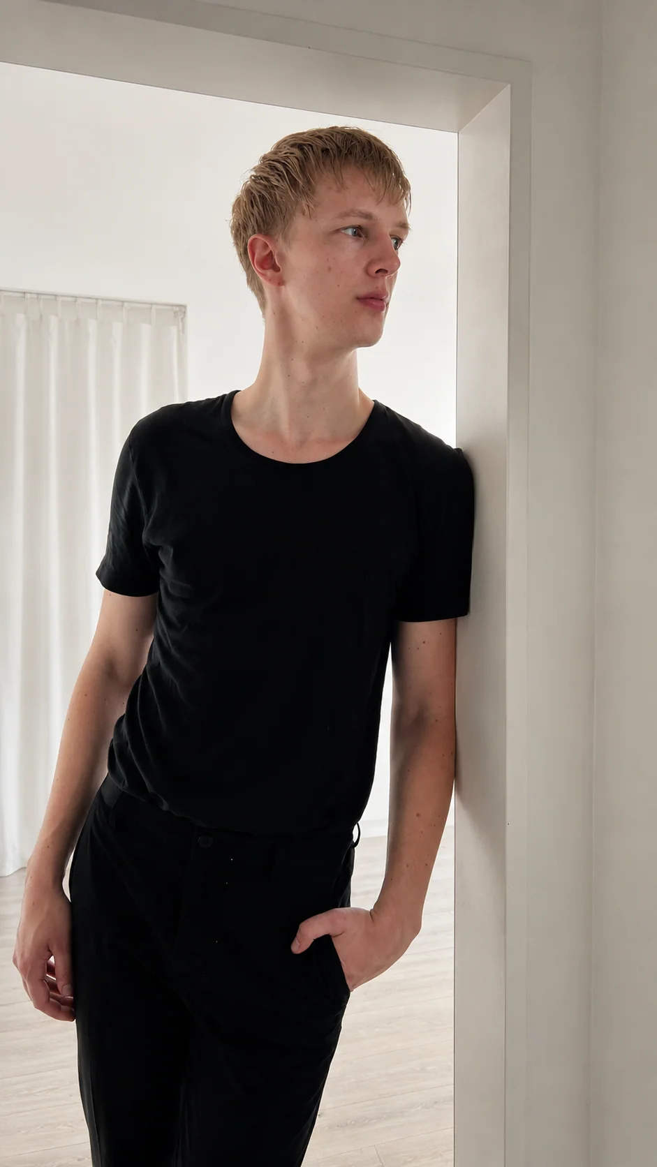 Lars Möllering steht in einem hellen Türrahmen, schwarzes Outfit, ruhige architektonische Komposition.