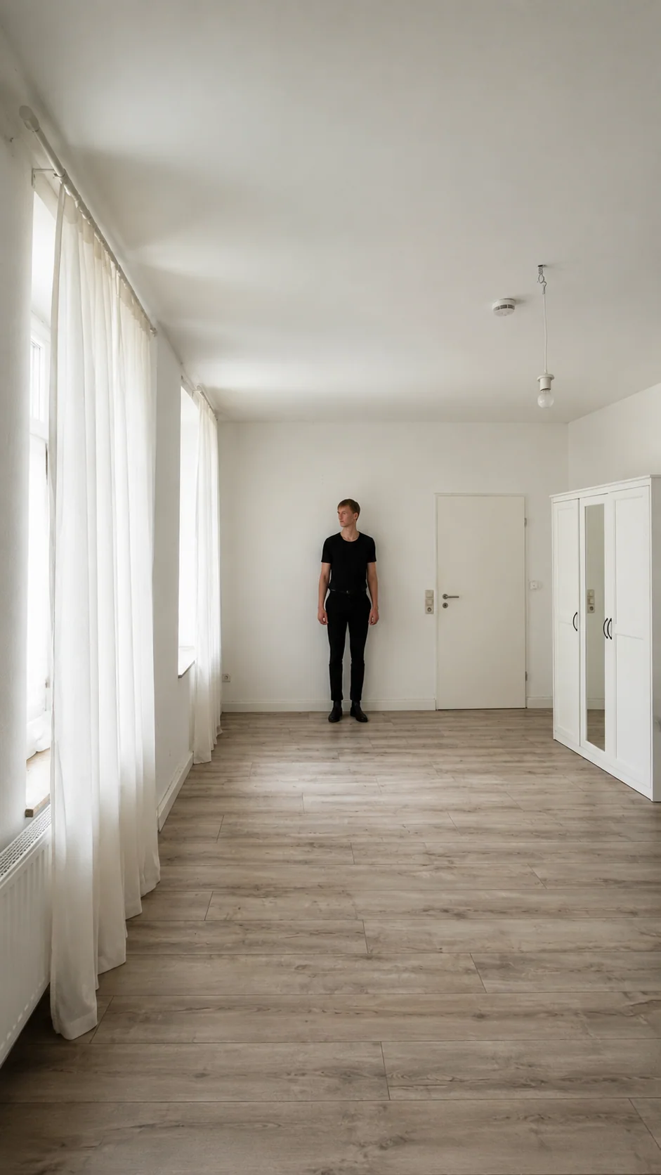 Lars Möllering steht klein in einem hellen leeren Raum, viel Weißraum und ruhige Distanz.