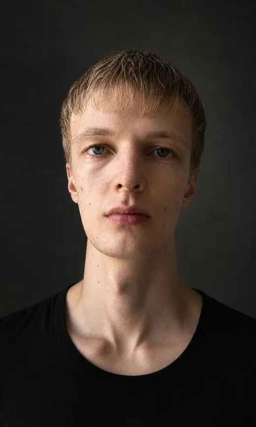Dunkles konzentriertes Portrait von Lars Möllering mit Gesicht, Hals und ruhigem Blick leicht über die Kamera.