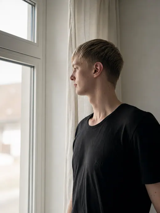 Seitliches Fensterportrait von Lars Möllering mit weichem Licht, ruhigem Profil und konzentrierter Haltung.